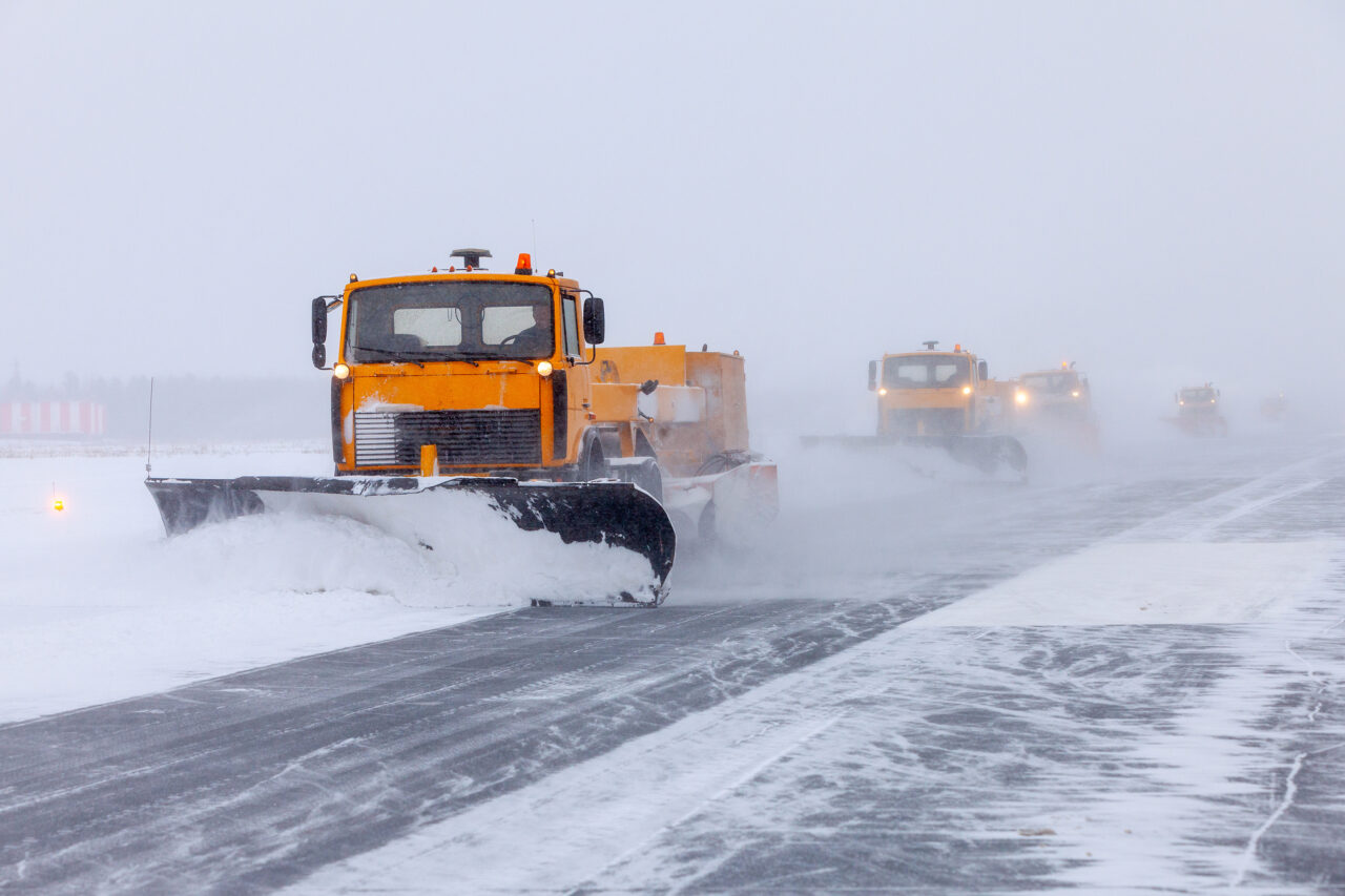 Snow plow on the runway in a snowstorm